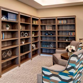 A cozy library corner with bookshelves and comfortable seating.