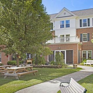 A peaceful residential courtyard with benches, trees, and a well-maintained garden.
