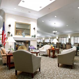 A spacious and well-lit lounge area with comfortable seating and a fireplace.