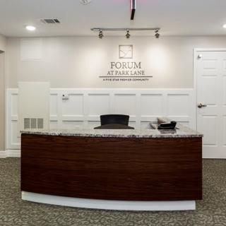 A modern office reception area with a wooden desk and decorative wall paneling.
