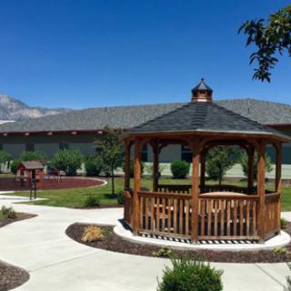 A beautifully landscaped garden featuring a wooden gazebo and winding pathways.