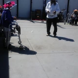 A caregiver interacting with a person in a wheelchair in a community setting.