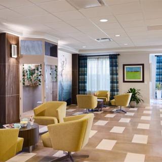 A modern lobby with yellow chairs and artwork on the walls.