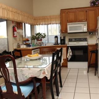 A cozy kitchen with a dining table and various appliances.