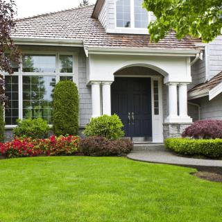 A beautiful residential house with a well-maintained garden and lush green lawn.