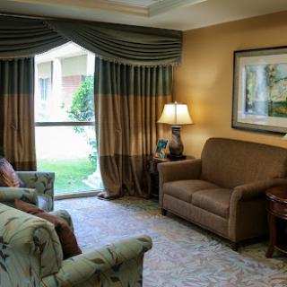 A cozy living room featuring elegant curtains, a comfortable sofa, and tasteful decor.