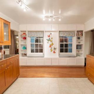 A modern kitchen interior featuring wooden cabinets and shelving with overhead lighting.