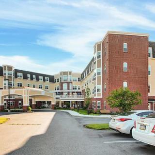 A modern medical facility with a parking lot in front.
