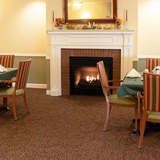 A cozy dining area featuring a warm fireplace and neatly arranged tables and chairs.