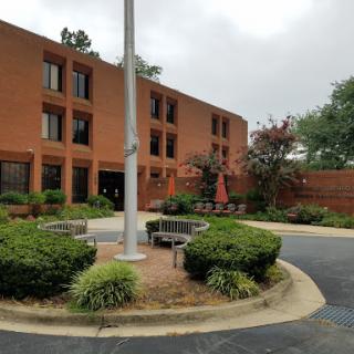 A cozy hotel setting featuring a red brick exterior and landscaped greenery.