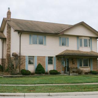 A suburban two-story house with a neatly trimmed lawn.