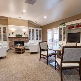 A spacious and elegantly designed living room with a cozy seating area, fireplace, and modern furniture.