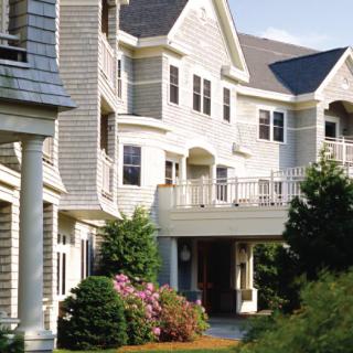 A view of a residential building with a landscaped exterior and greenery.