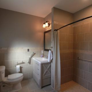 A modern bathroom with a toilet, sink, and walk-in shower.