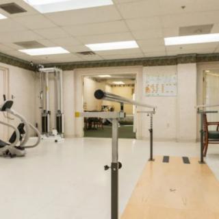 A physical therapy room equipped with parallel bars and exercise equipment.