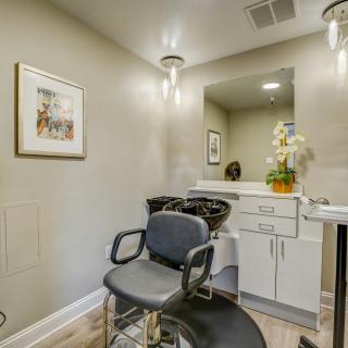 A modern hair salon with a comfortable barber chair, stylish decor, and well-lit interior.