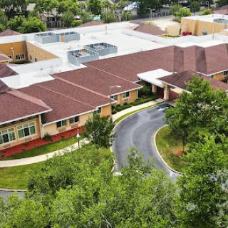 Aerial view of a modern healthcare facility surrounded by greenery.