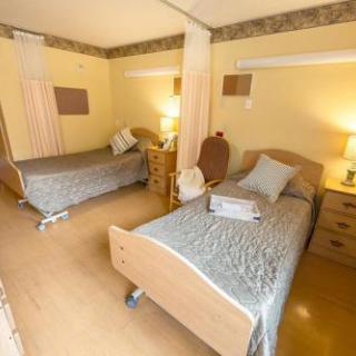 A cozy hospital room with two separate beds, designed for comfort and ease.