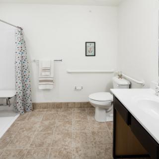 A modern bathroom with a shower, toilet, and sink.