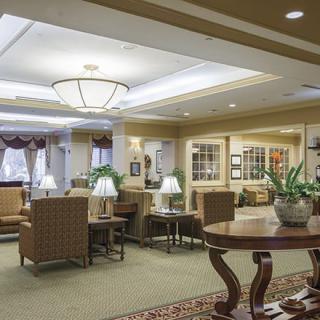 A well-lit lobby featuring comfortable seating areas, decorative plants, and elegant lighting fixtures.