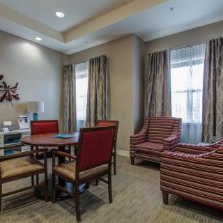 A cozy living room with comfortable chairs, a table, and elegant decor.