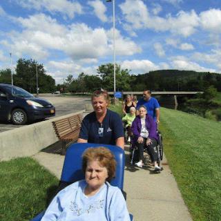 A group of individuals enjoying a day out in wheelchairs, surrounded by nature.