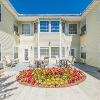 A bright courtyard with colorful flowers and outdoor seating areas.
