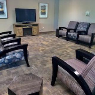 A comfortable waiting room featuring a variety of chairs and a television.