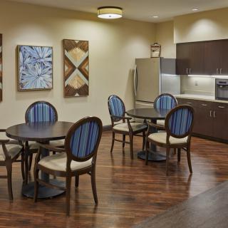 A modern kitchen and dining area with stylish furniture and artwork on the walls.