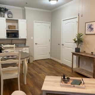 A cozy and modern combined kitchen and dining area with light-colored furniture and decor.