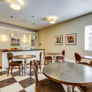 A cozy cafe interior with round tables, wooden chairs, and a checkered floor.