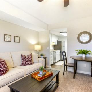 A cozy living room with a sofa, coffee table, and adjoining dining area.
