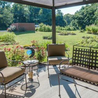 A cozy patio setup with chairs and a table overlooking a lush garden.