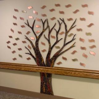 A wall decorated with a tree mural featuring branches and leaves.