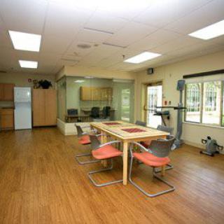 A spacious and modern kitchen with a dining area, featuring wooden flooring and contemporary furniture.
