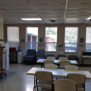 A bright and inviting communal dining area with tables, chairs, and large windows.