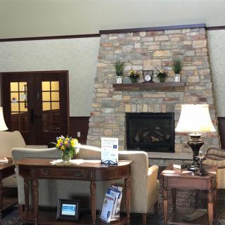 A cozy living room featuring a stone fireplace and comfortable seating with elegant lamps.