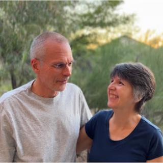 A couple enjoying a joyful moment together in a natural setting.