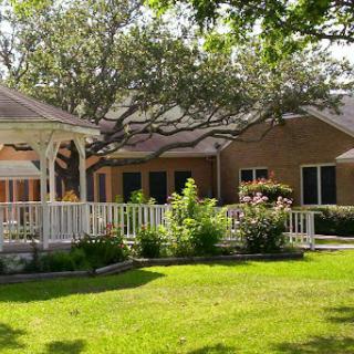 A charming house surrounded by lush greenery and a well-maintained garden.
