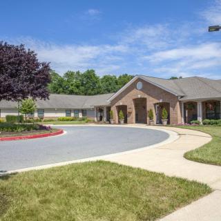 A suburban building with a circular driveway and landscaped surroundings.