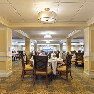 A spacious and elegantly decorated dining room with neatly arranged tables and chairs.