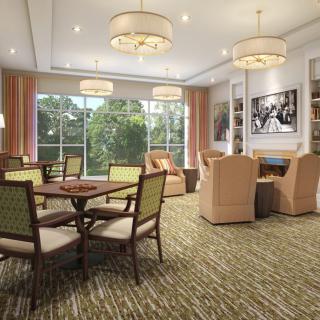 A cozy living room with comfortable seating, a round table, and large windows providing natural light.