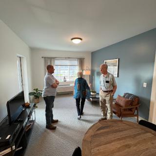 Three individuals engaged in conversation in a well-lit interior space.