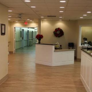 A well-lit reception area with a desk and hallway in the background.