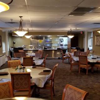 An empty restaurant dining area with neatly arranged tables and chairs.