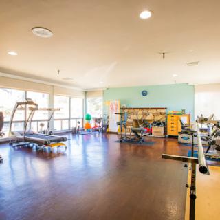 A well-equipped gym area featuring various exercise machines and a spacious workout environment.