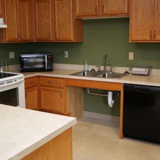 A modern kitchen with wooden cabinets, a countertop, and various appliances.