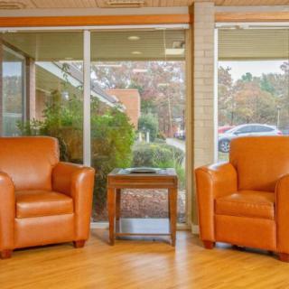 A cozy waiting area with two leather armchairs and a small table by the window.