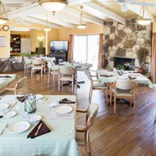 A cozy dining area with neatly arranged tables and a warm fireplace.