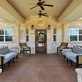 A stylish porch with comfortable outdoor seating and ceiling fans.